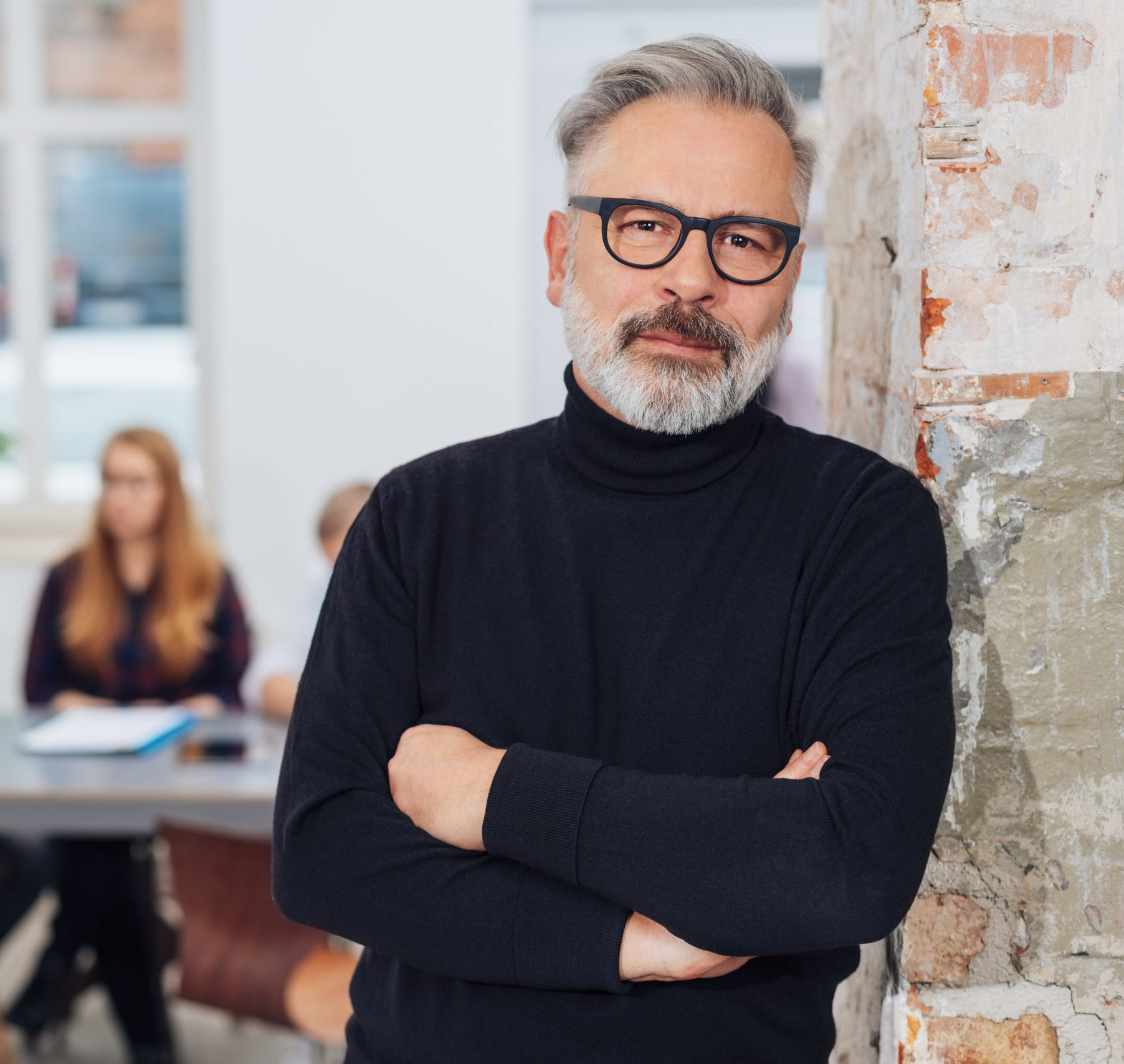 Confident mature grey-haired man in office